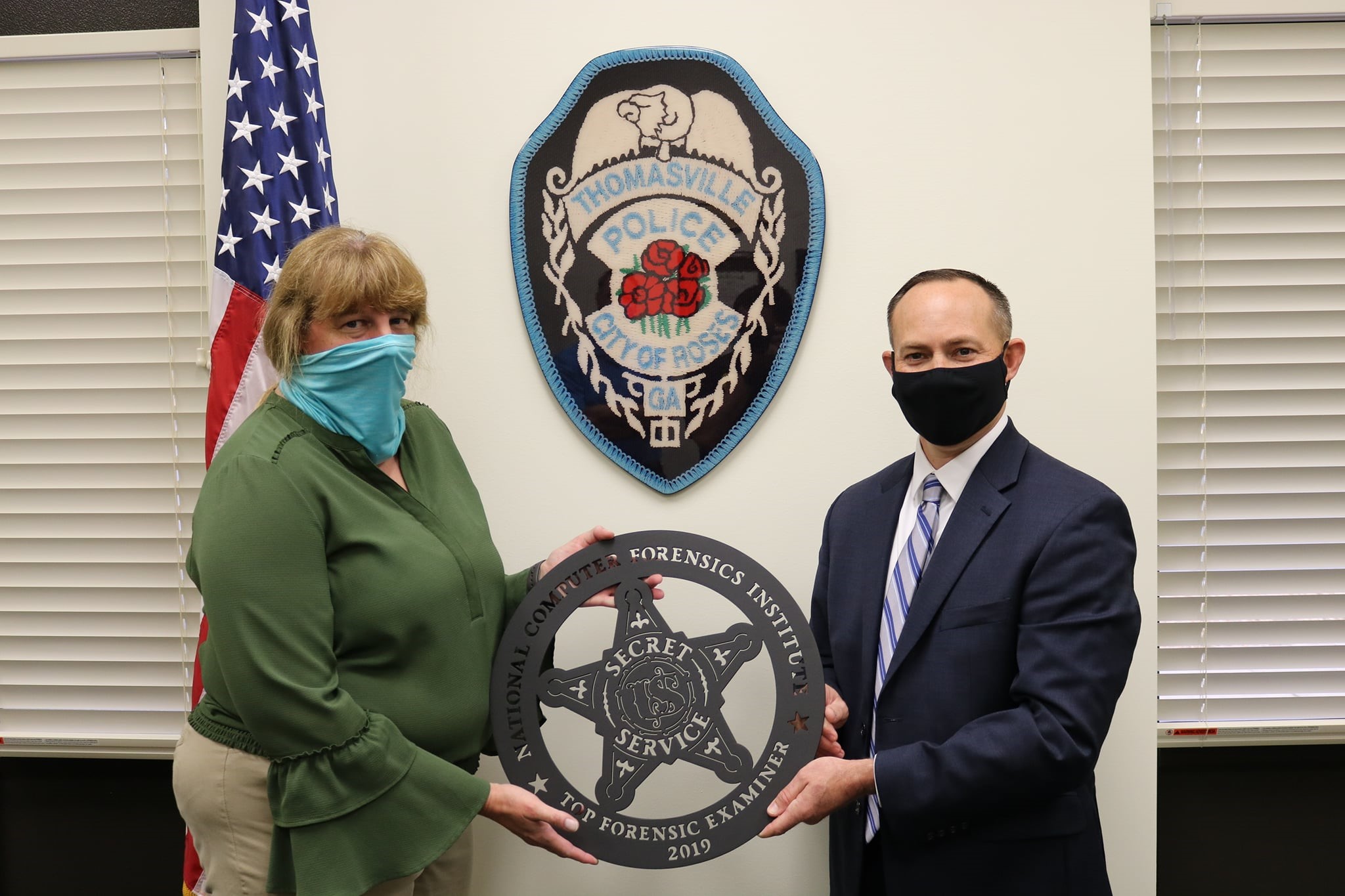 Detective Lisa Maxwell receives an award as one of the Top Digital Forensic Expert Examiners from USSS Resident Agent in Charge Clint Bush. 